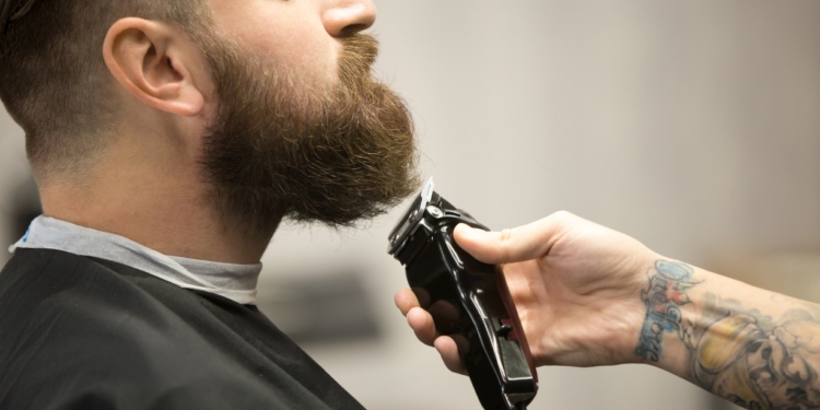 Beard: Essential tips for growth and grooming Beauty men shaving himself with an electric razor